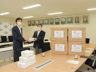 写真　加藤理事からマスクを受け取る市長